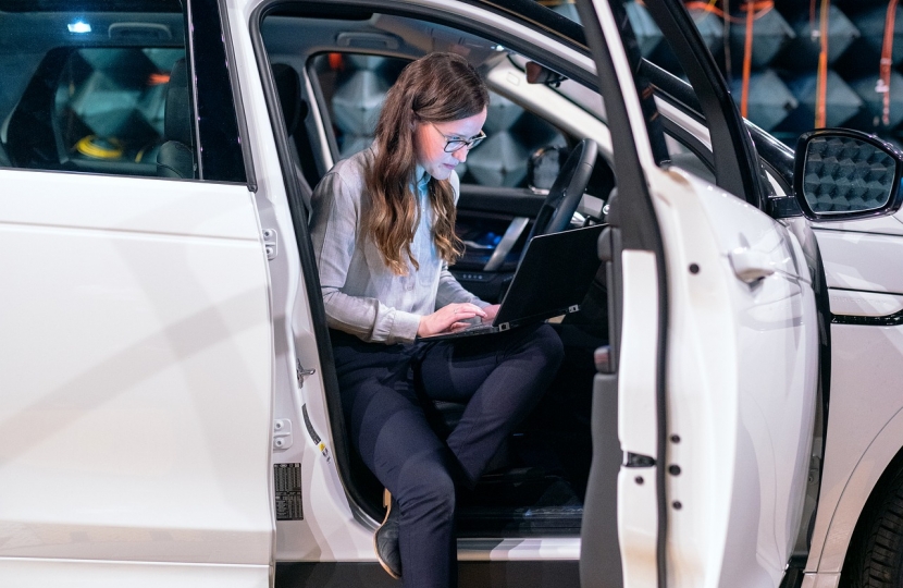 A technician with a laptop at a car production plant.